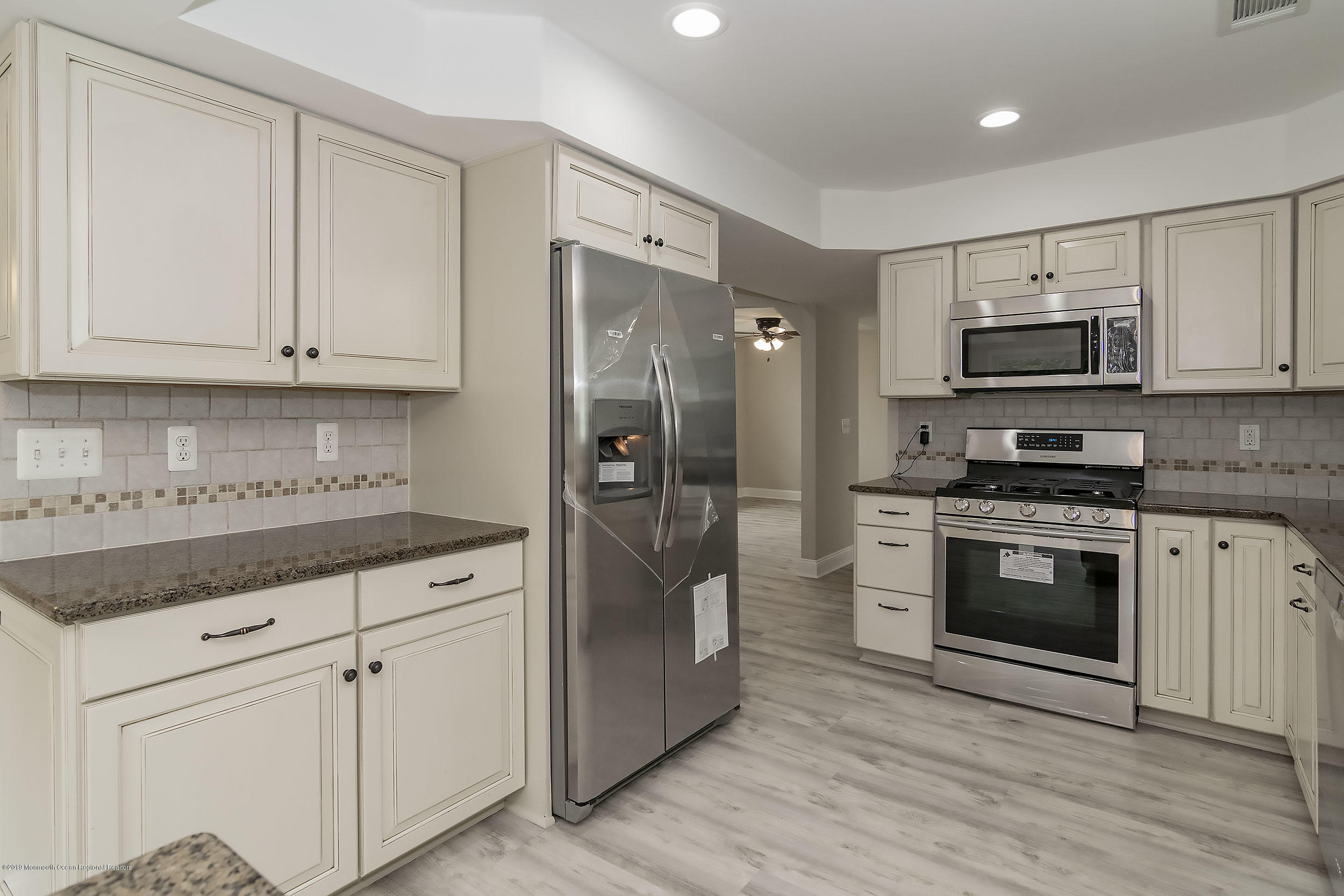 1521 Treeneedle Road Point Pleasant, NJ 08742 - Photo 5 of 33 a kitchen with granite countertop a refrigerator and a stove top oven