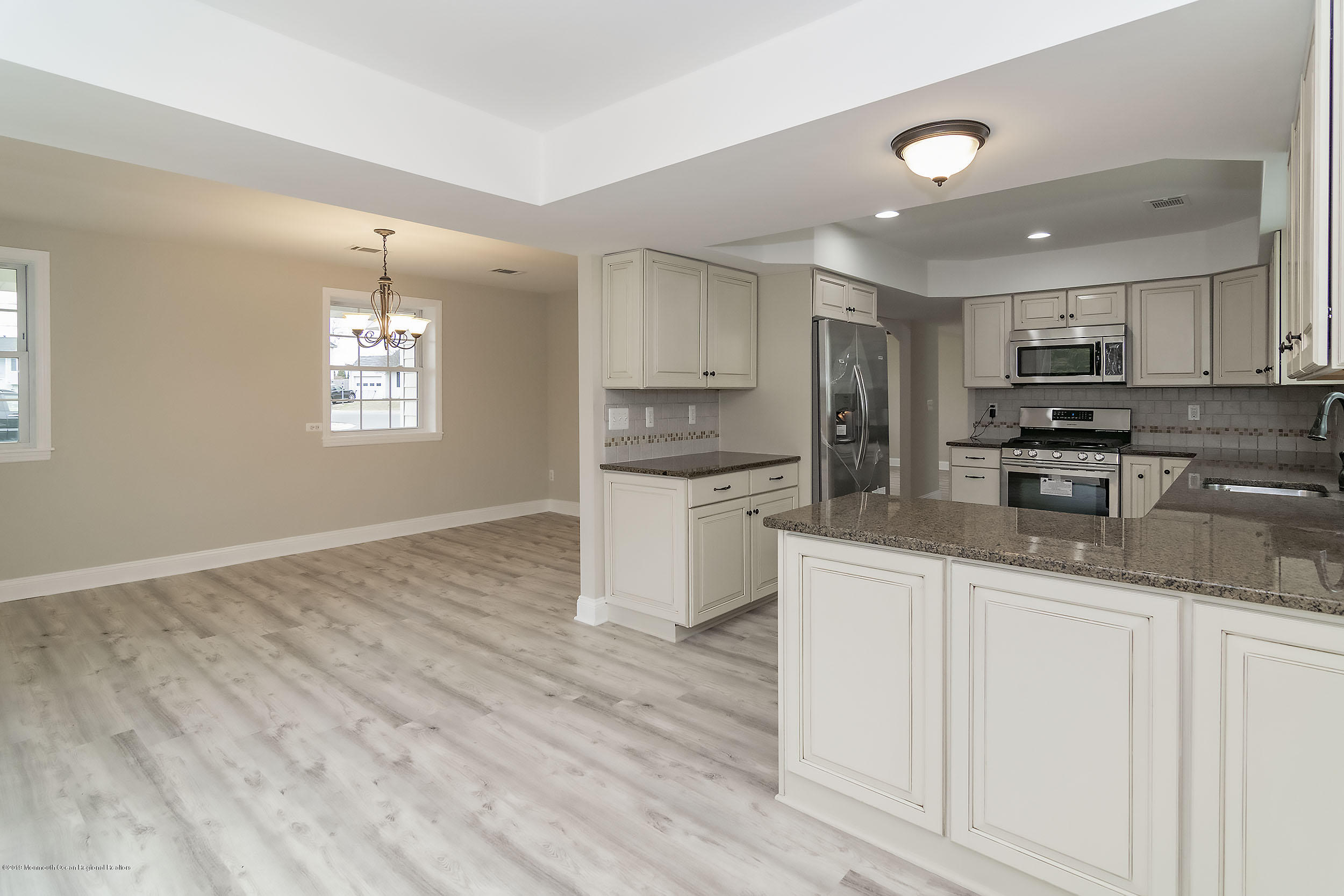 1521 Treeneedle Road Point Pleasant, NJ 08742 - Photo 7 of 33 a kitchen with granite countertop white cabinets and white appliances