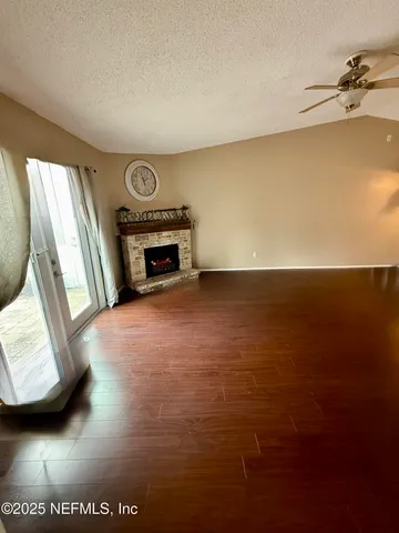 a view of an empty room with a fireplace and a window