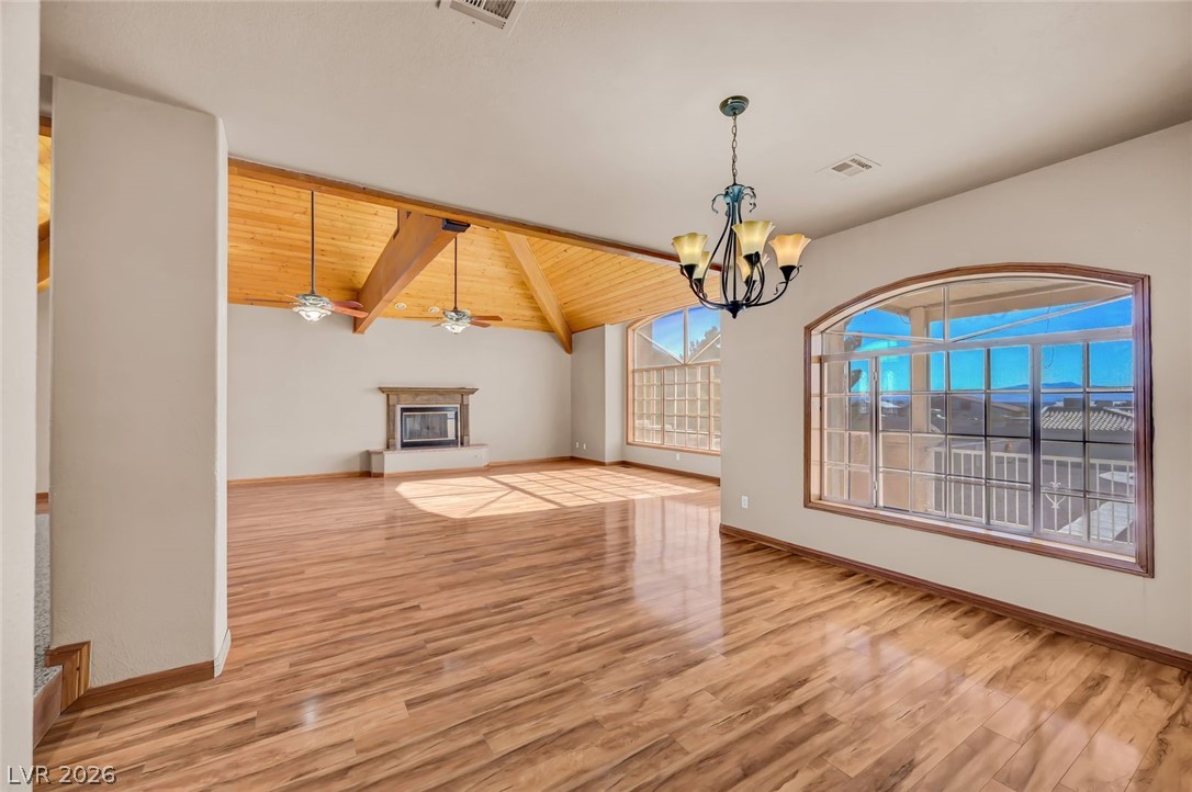 640 North Racetrack Road Henderson, NV 89015 - Photo 20 of 65 A living space featuring vaulted ceilings, wide plank flooring, and a classic fireplace.
