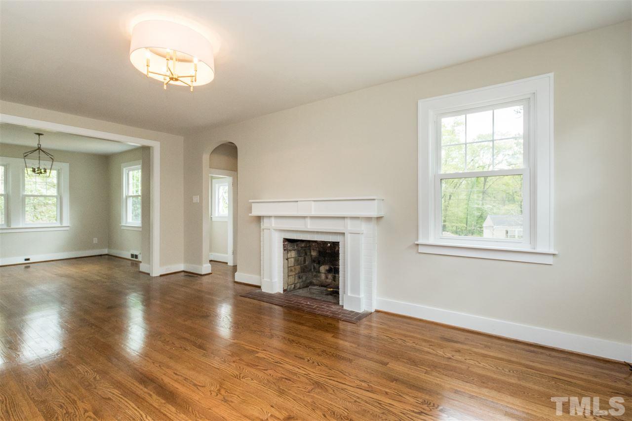 2503 Mayview Road Raleigh, NC 27607 - Photo 8 of 20 an empty room with wooden floor windows and fireplace