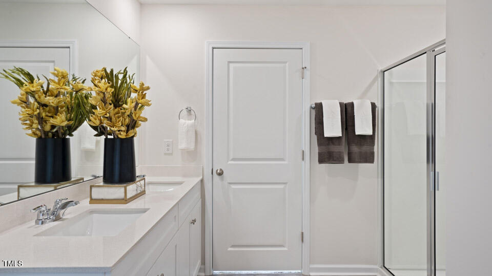 5917 Sodium Street Raleigh, NC 27610 - Photo 9 of 24 a bathroom with a granite countertop sink a mirror and shower