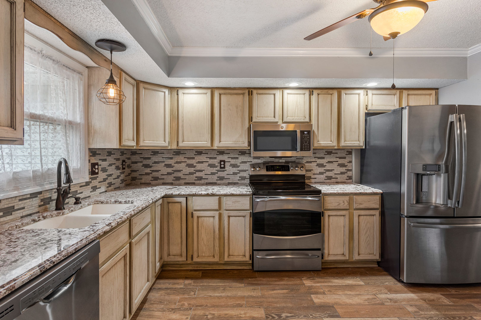 2211 Carlisle Drive Champaign, IL 61821 - Photo 8 of 34 a kitchen with stainless steel appliances granite countertop a sink a stove a refrigerator cabinets and a wooden floor