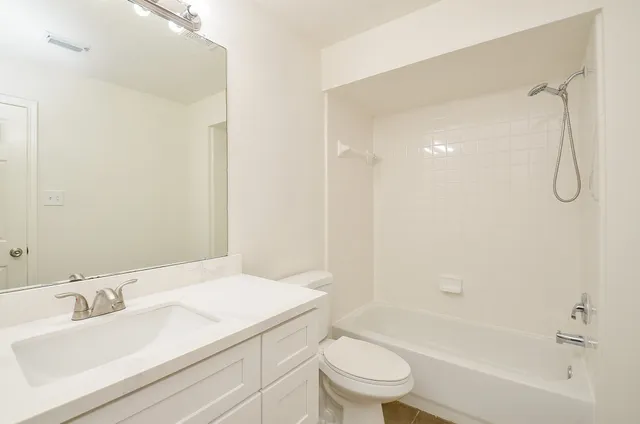 a bathroom with a granite countertop sink a toilet and shower