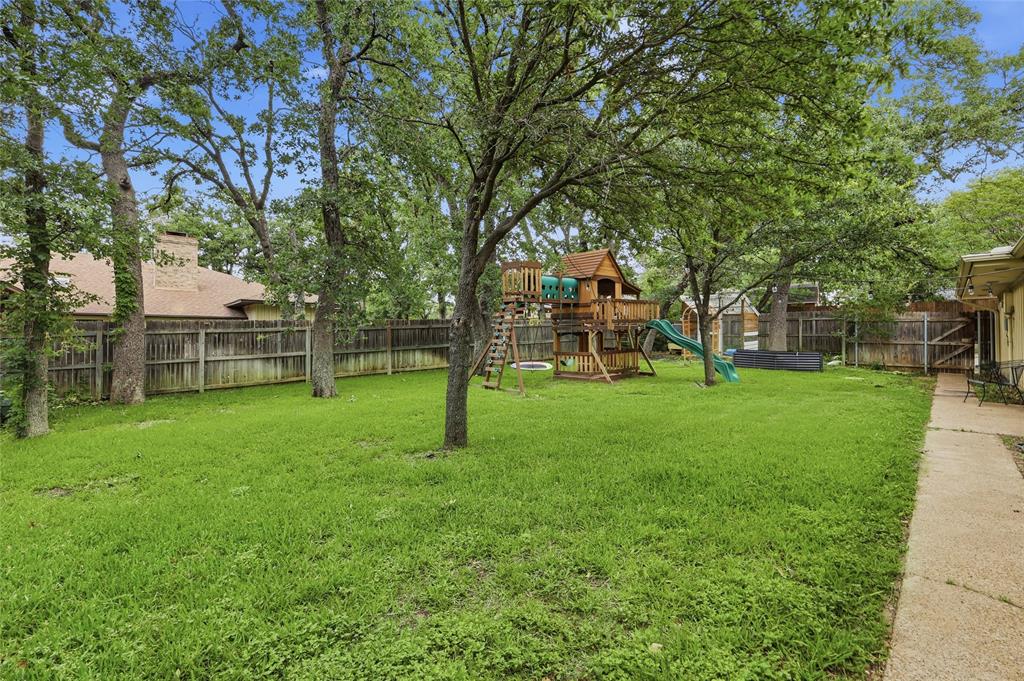 823 Ridgecrest Circle Denton, TX 76205 - Photo 40 of 40 Spacious backyard featuring a large lawn, mature trees, and a perimeter wooden fence