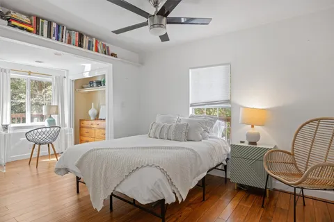 a bedroom with a bed a chair and a chandelier