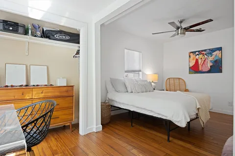 a bedroom with a bed and wooden floor