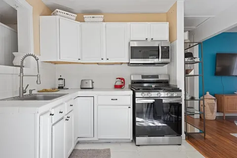 a kitchen with stainless steel appliances granite countertop a stove microwave and cabinets