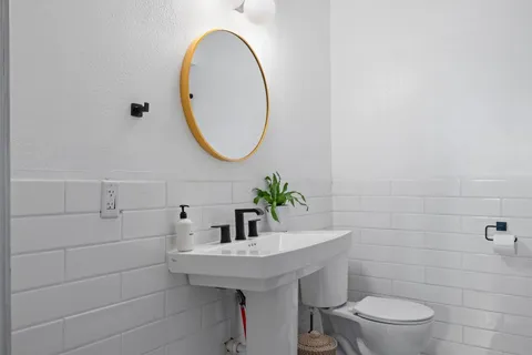 a bathroom with a sink a toilet and a mirror