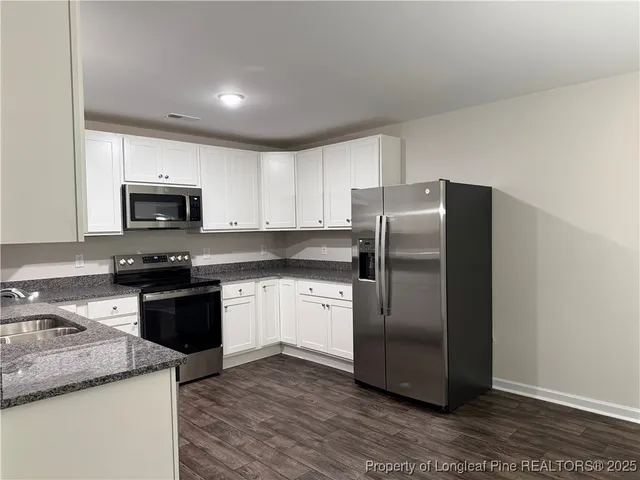 a kitchen with a stove top microwave and refrigerator