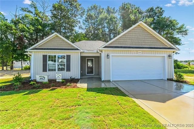 a front view of a house with a yard and potted plants