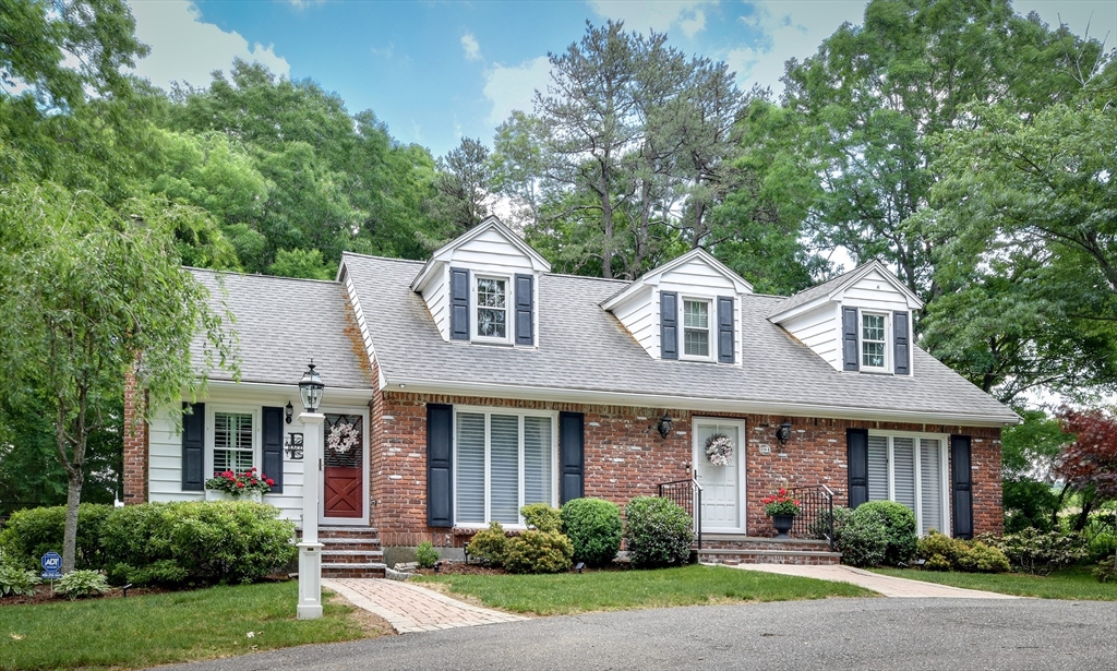 a front view of a house with a yard and trees