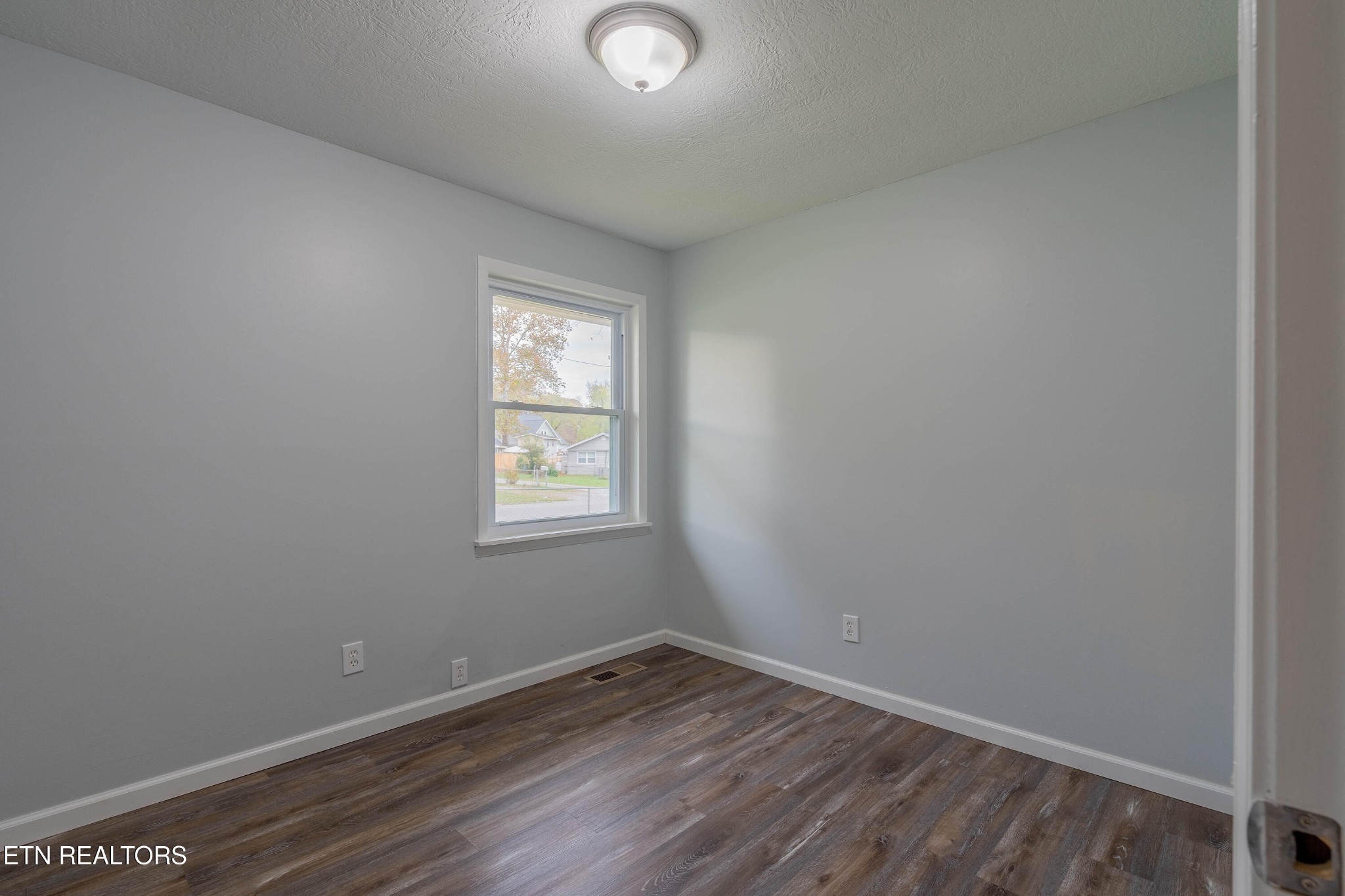 115 Manchester Road Oak Ridge, TN 37830 - Photo 12 of 22 an empty room with wooden floor and windows