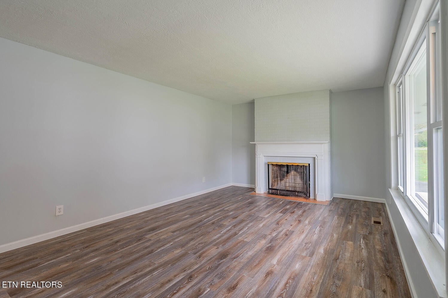 115 Manchester Road Oak Ridge, TN 37830 - Photo 4 of 22 wooden floor fireplace and windows in an empty room