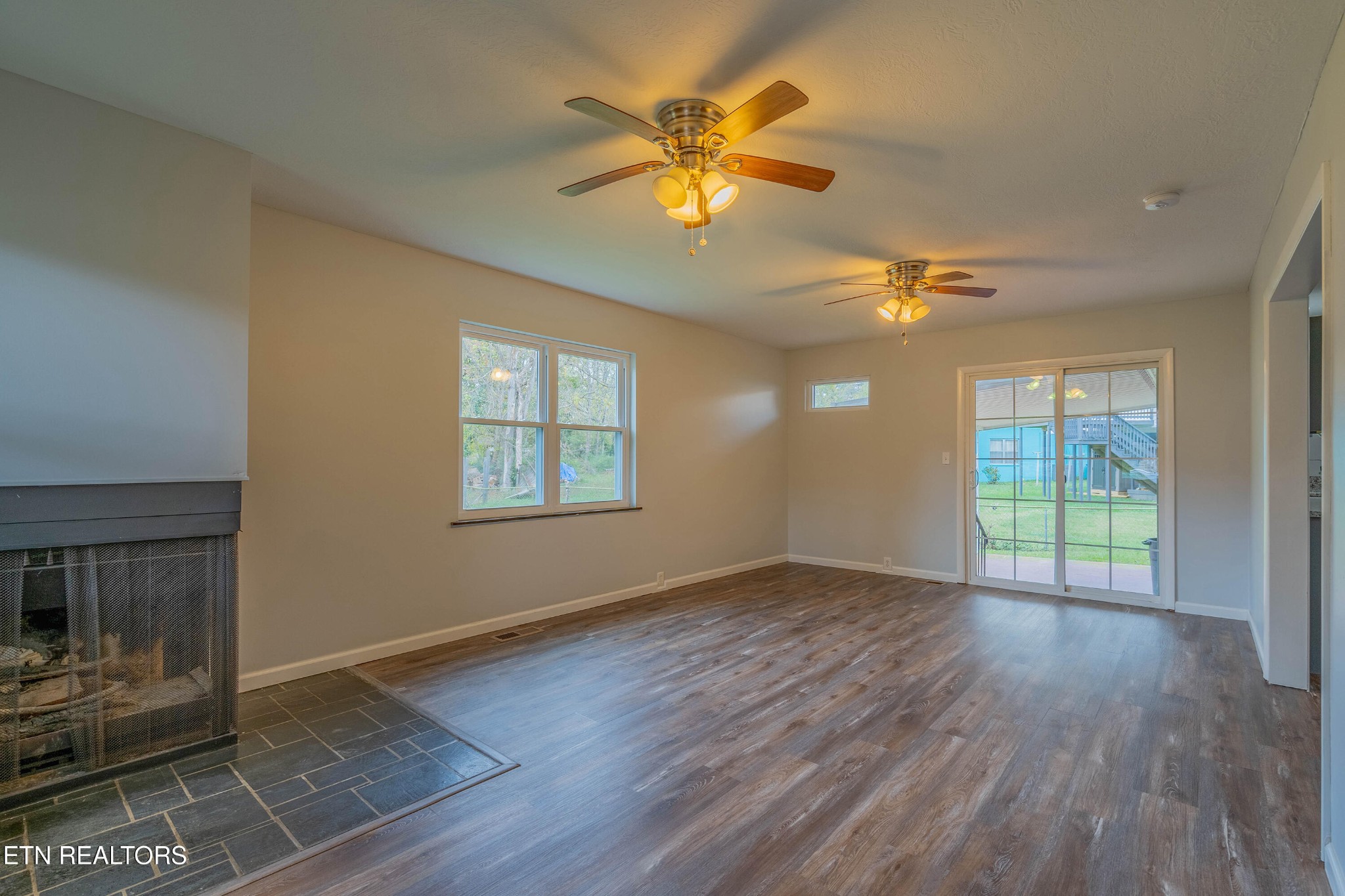 115 Manchester Road Oak Ridge, TN 37830 - Photo 6 of 22 an empty room with wooden floor fan and windows