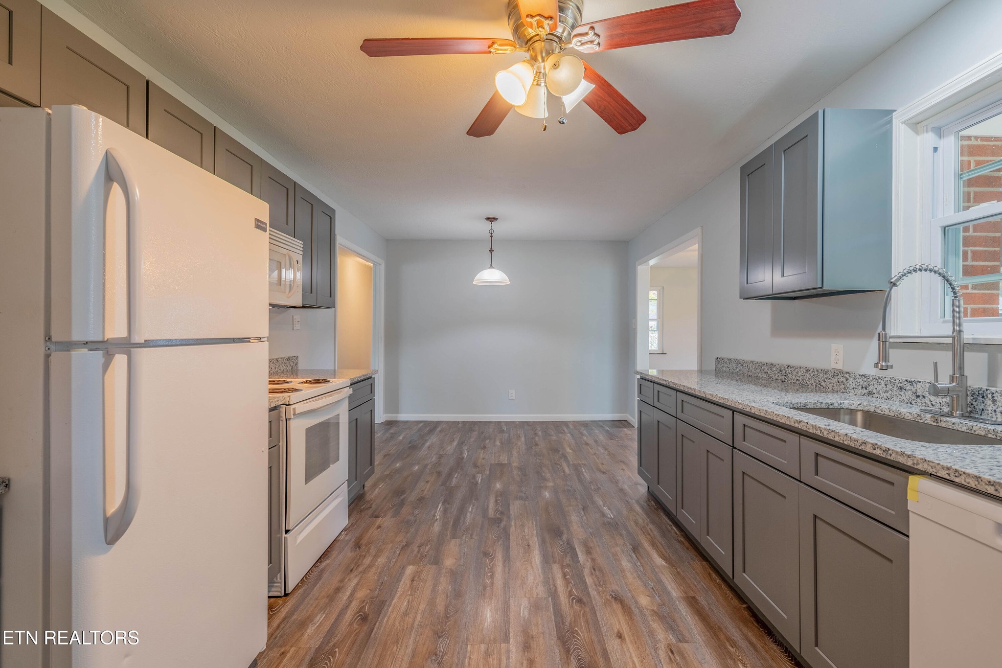 115 Manchester Road Oak Ridge, TN 37830 - Photo 9 of 22 a kitchen with stainless steel appliances granite countertop a refrigerator a sink and white cabinets