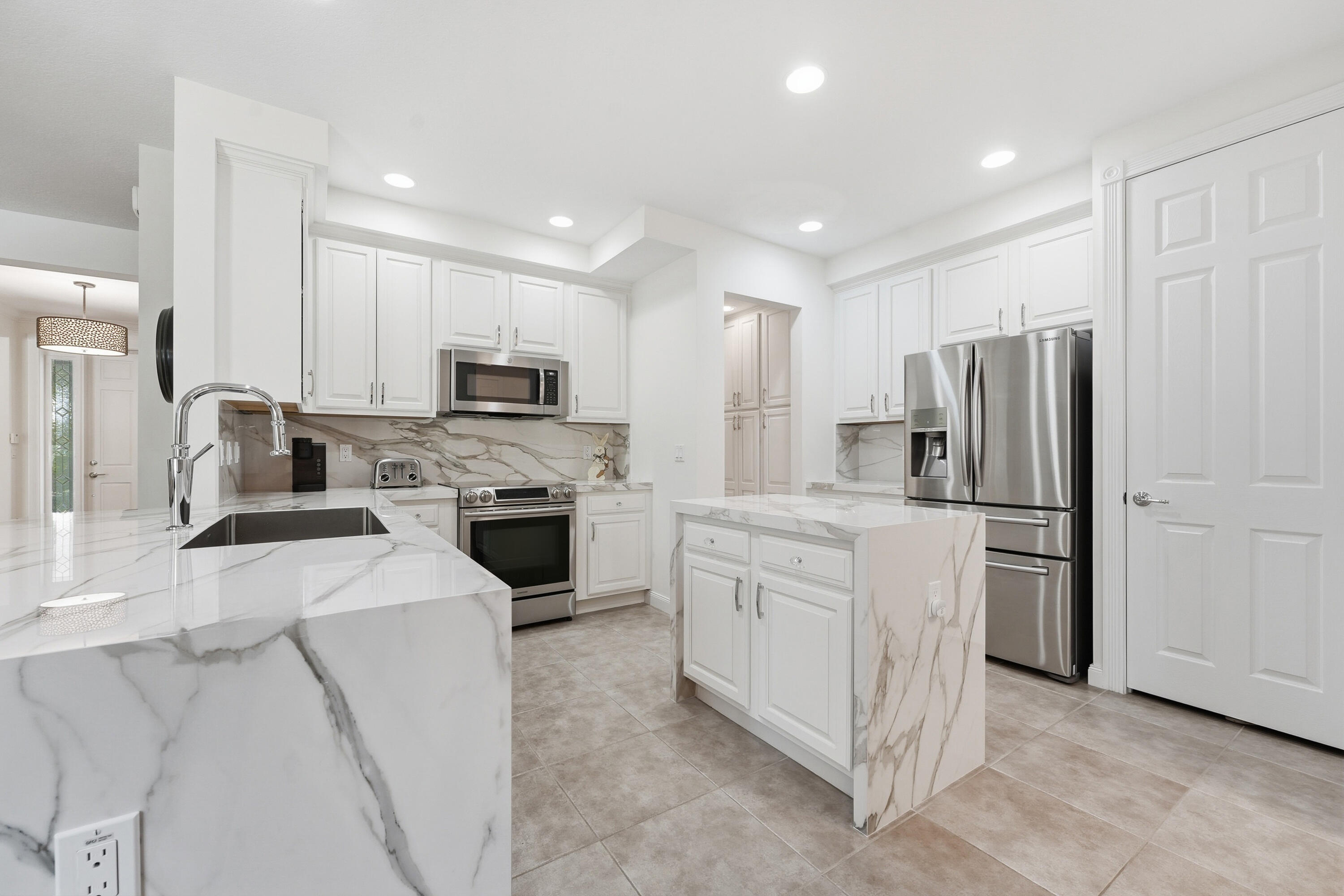 3443 South Caroline Street Jupiter, FL 33458 - Photo 13 of 60 a kitchen with cabinets and stainless steel appliances