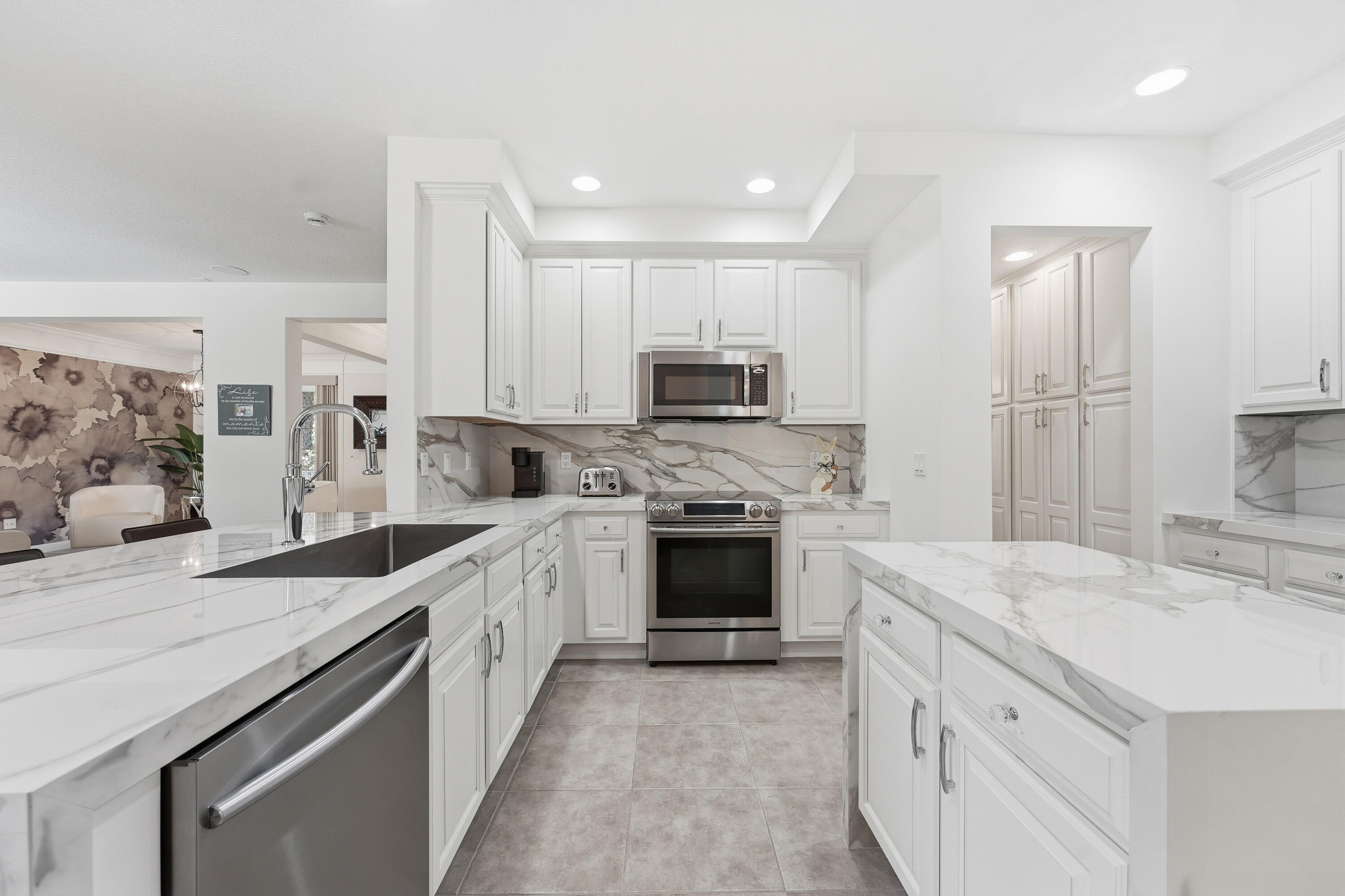 3443 South Caroline Street Jupiter, FL 33458 - Photo 14 of 60 a large kitchen with granite countertop a sink and white cabinets