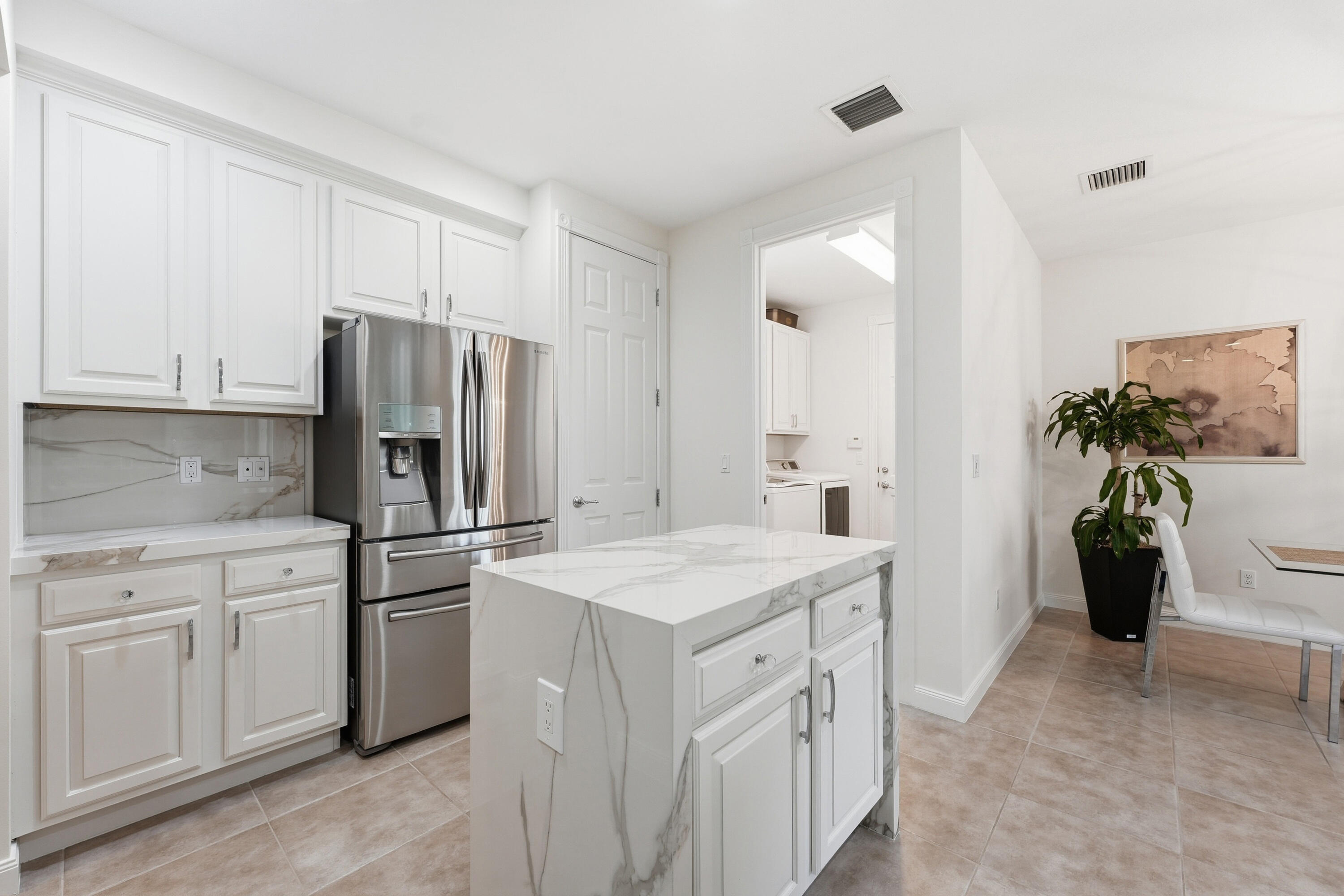 3443 South Caroline Street Jupiter, FL 33458 - Photo 15 of 60 a kitchen with white cabinets and refrigerator