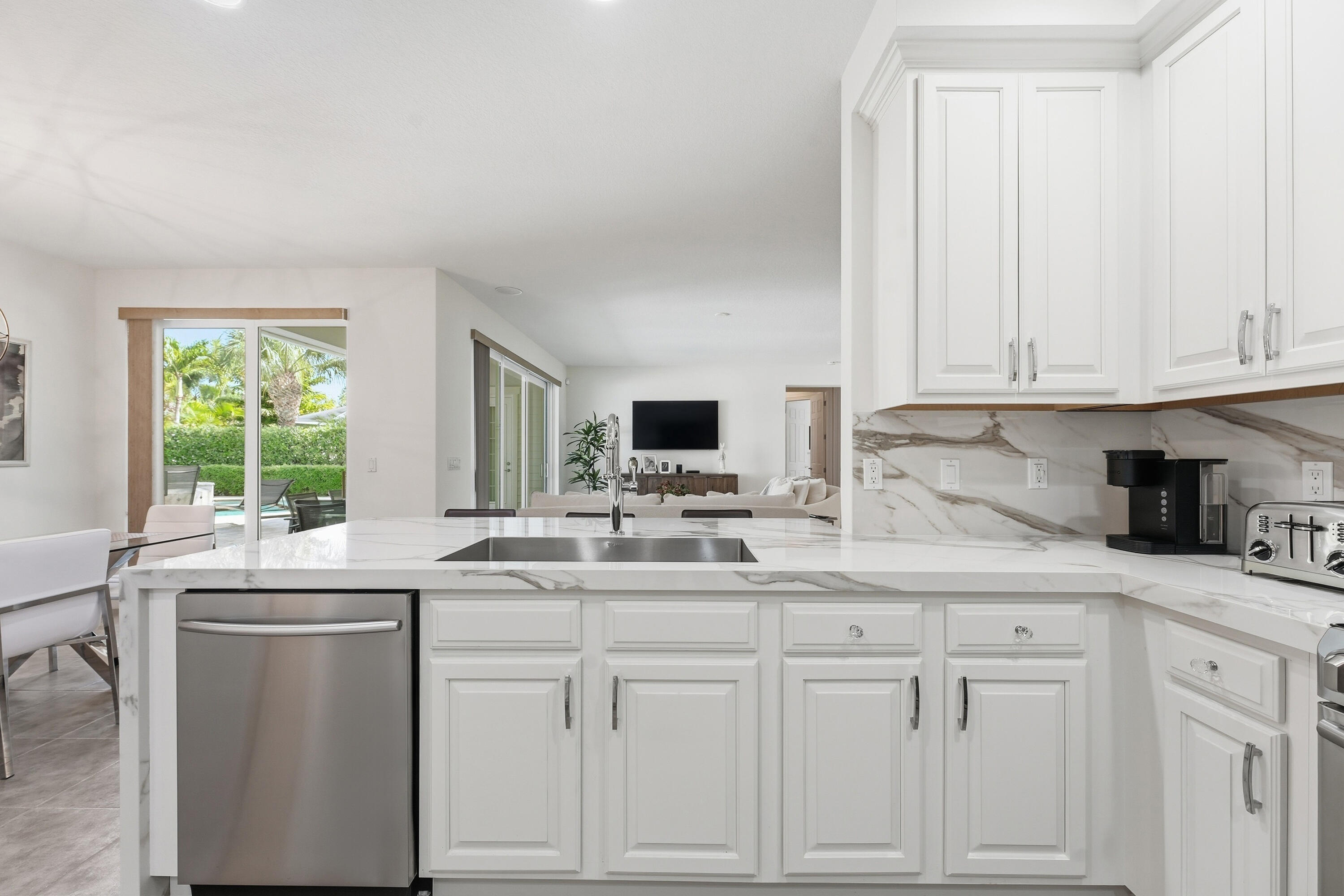 3443 South Caroline Street Jupiter, FL 33458 - Photo 16 of 60 a kitchen with white cabinets and sink