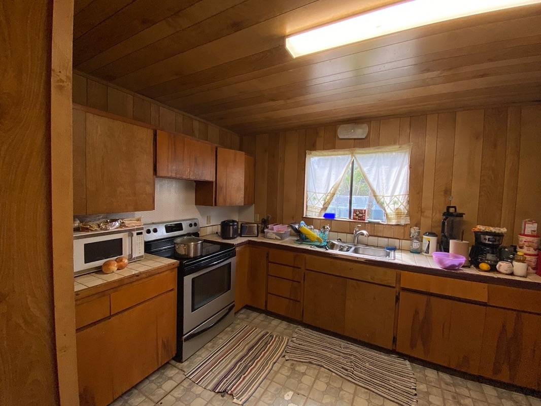 a kitchen with sink a stove and cabinets