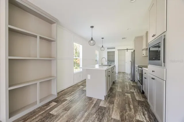 a kitchen with cabinets and wooden floor