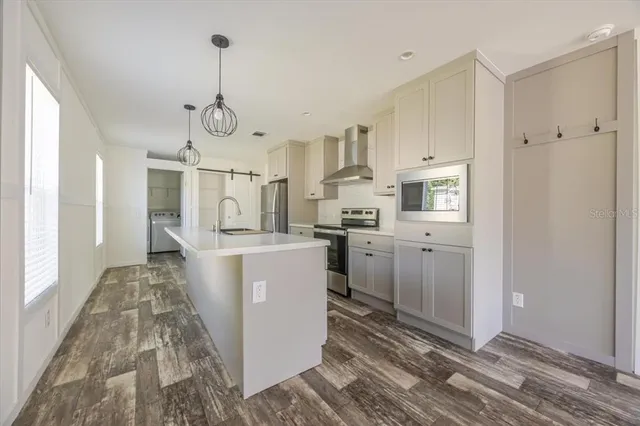 a open kitchen with white cabinets and stainless steel appliances
