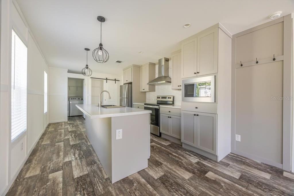326 Smith Road Polk City, FL 33868 - Photo 14 of 26 a open kitchen with white cabinets and stainless steel appliances