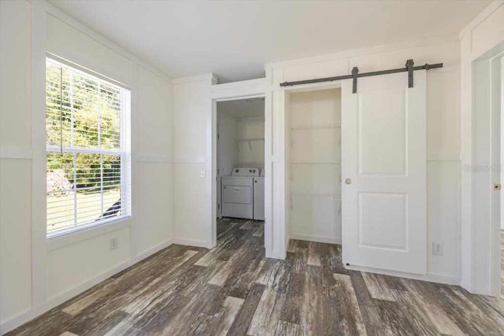 326 Smith Road Polk City, FL 33868 - Photo 17 of 26 a view of an empty room with wooden floor and a window