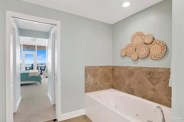 a bathroom with a tub and a view of bathroom