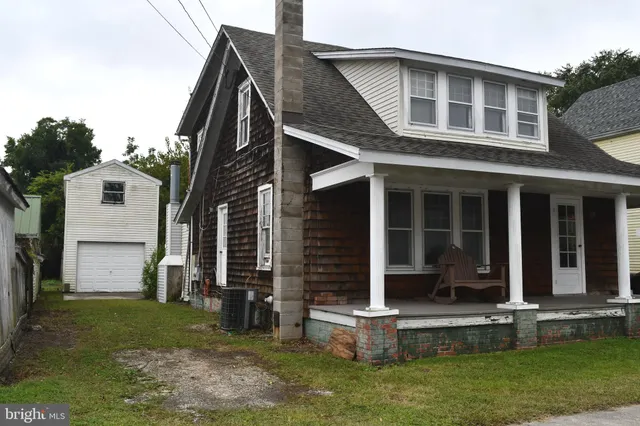 a front view of house with a garden