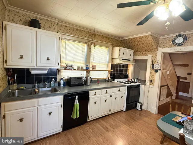 a kitchen with stainless steel appliances granite countertop a stove a sink and white cabinets