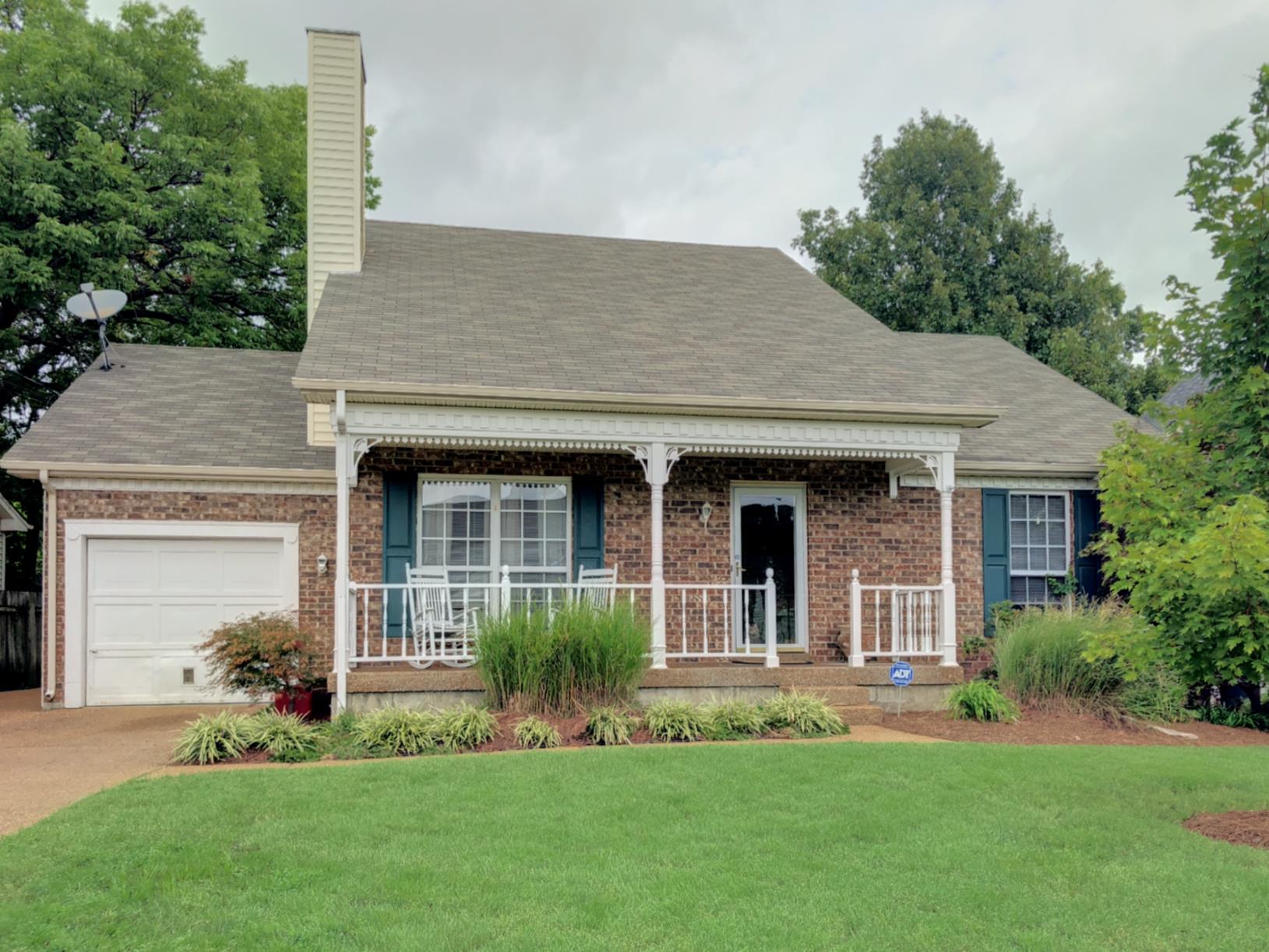 a front view of a house with a garden and yard