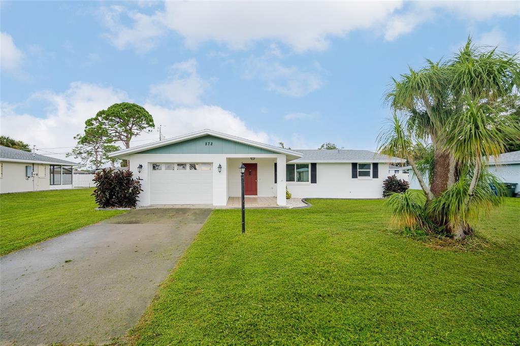 872 Mohawk Road Venice, FL 34293 - Photo 1 of 1 a view of a yard in front of a house with plants and large tree