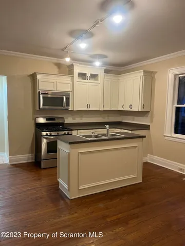 a kitchen with stainless steel appliances granite countertop a stove and a microwave