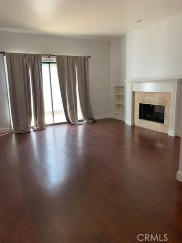 an empty room with wooden floor and fireplace