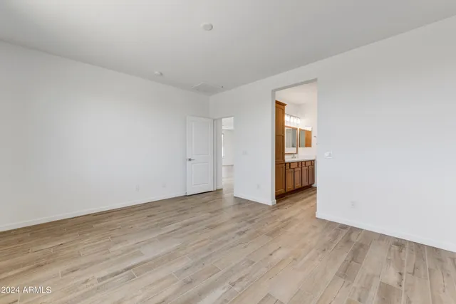 a view of an empty room with wooden floor and closet