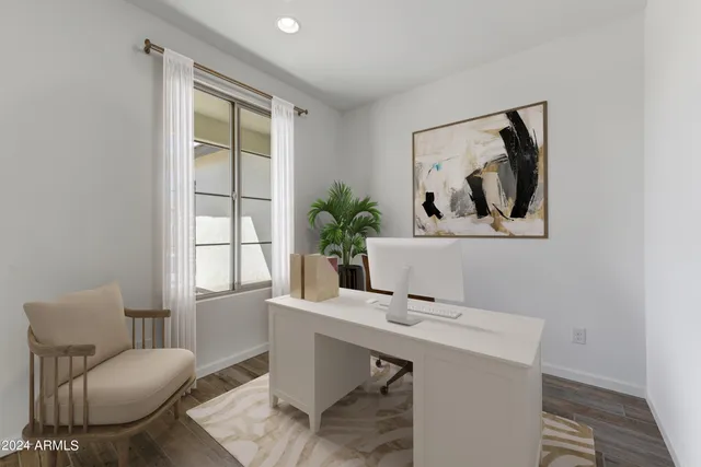 a view of a workspace with furniture and a window