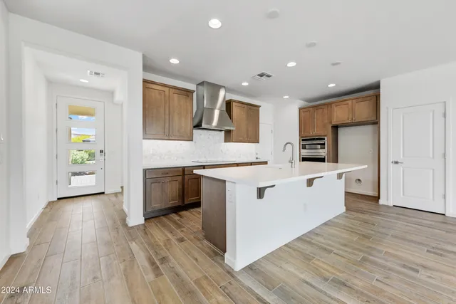 a large kitchen with stainless steel appliances granite countertop a large counter top and a wooden floors