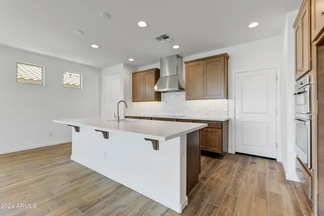 a kitchen with a sink cabinets and wooden floor