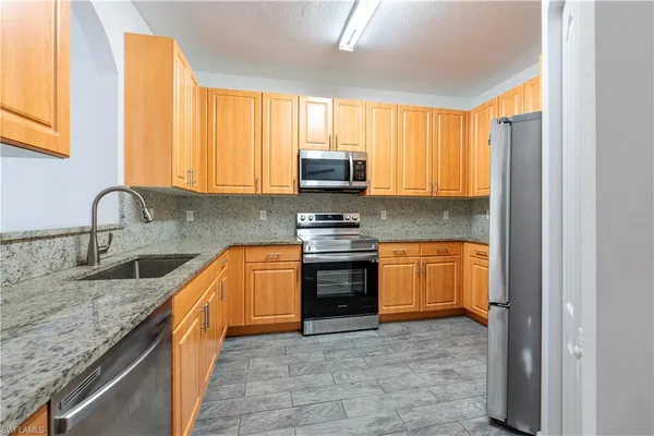 a kitchen with granite countertop a stove and a sink