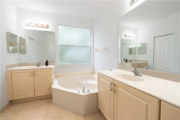 a bathroom with a tub sink and mirror