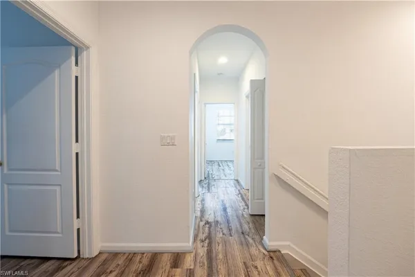 a view of a hallway with wooden floor and staircase