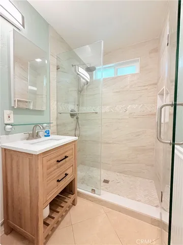 a bathroom with a shower sink vanity and mirror