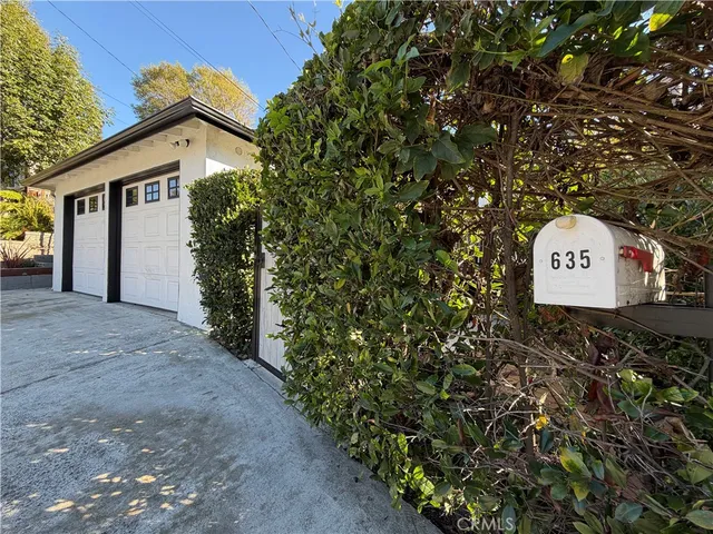a front view of a house with a yard and garden