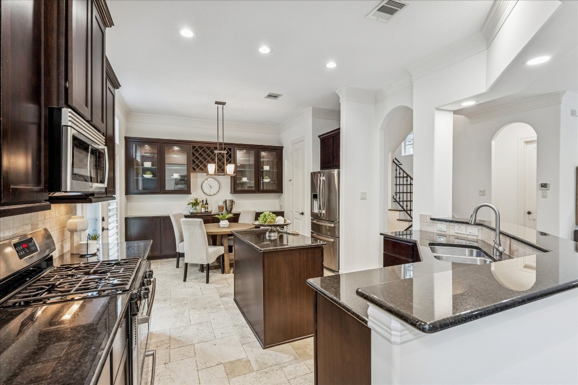 4418 Rose Street Houston, TX 77007 - Photo 10 of 34 Well appointed kitchen featuring tile flooring, stainless steel appliances, a gas range, a separate raised breakfast bar, and an island with a built in wine fridge, creating a polished and highly functional second level space.