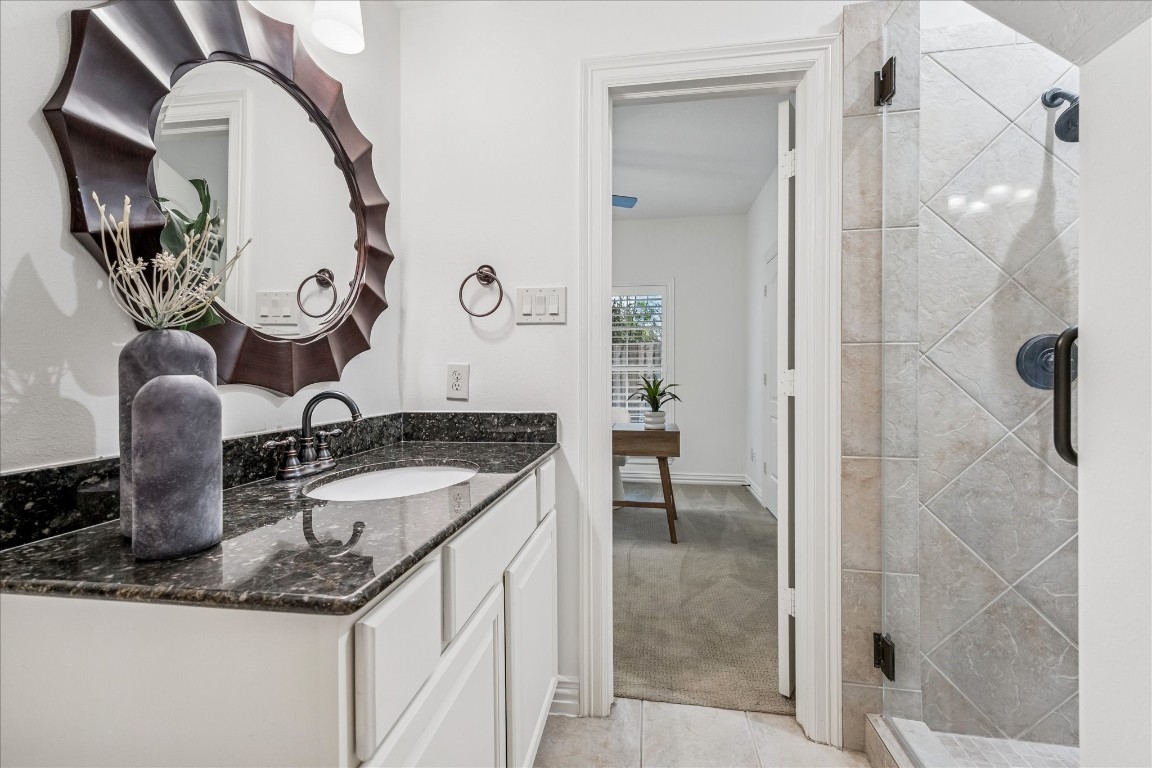 4418 Rose Street Houston, TX 77007 - Photo 31 of 34 a bathroom with a granite countertop sink a mirror and shower