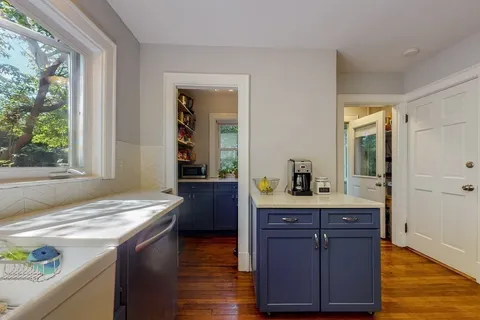 a room with granite countertop a sink and a wooden floor