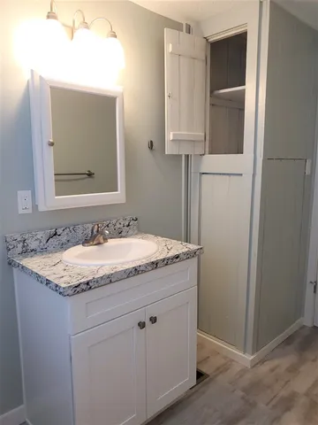 a bathroom with a granite countertop sink and a mirror