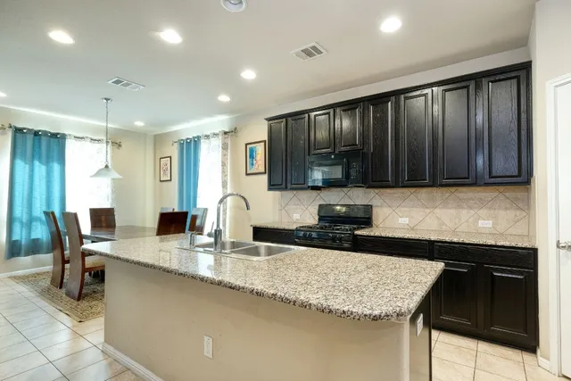 a kitchen with granite countertop sink cabinets and stainless steel appliances